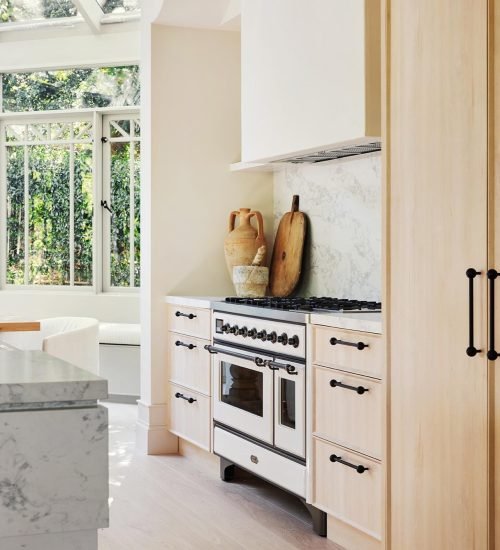 Bright kitchen remodel with custom cabinetry, marble countertops, and modern range.